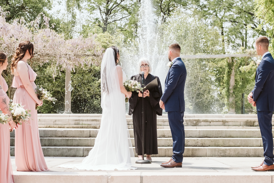 Bride and groom stand in front of officiant during wedding ceremony in New Orleans