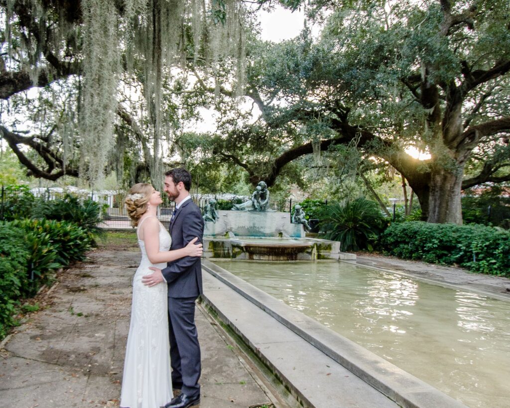 Newlyweds embrace at Hyams' Fountain at New Orleans Audubon Park