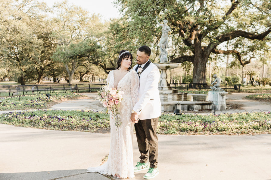 newlyweds stand in front of St. Charles Fountain in Audubon Park