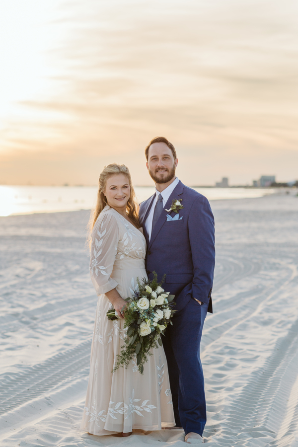 Newlyweds stand on the beach at sunset after their Biloxi Beach wedding | The Best Biloxi Beach Packages