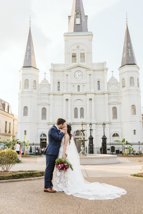 Newlyweds kiss in Jackson Square with St. Louis Cathedral in the background | The best places to elope in New Orleans