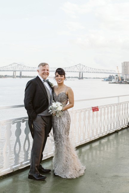 Newlyweds pose on a New Orleans riverboat along the Mississippi River | the best places to elope in New Orleans