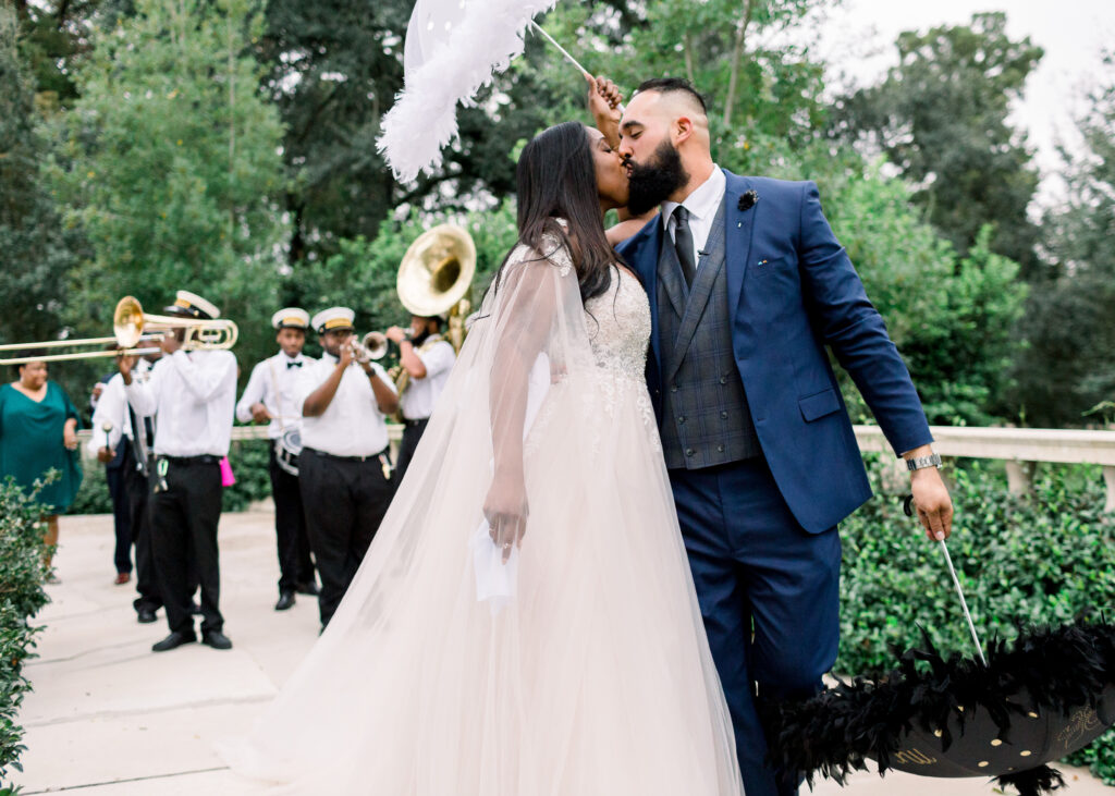 newlyweds kiss during second line parade