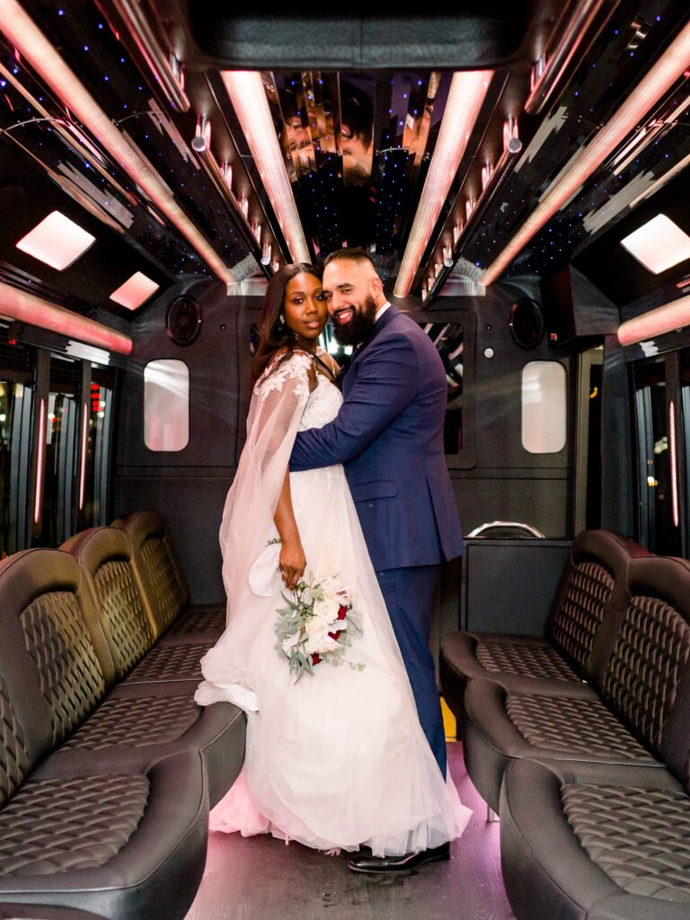 Newlyweds stand inside their limousine