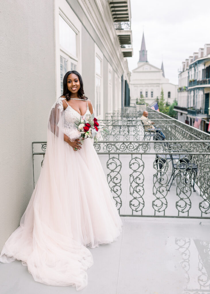 bride stands on French Quarter balcony